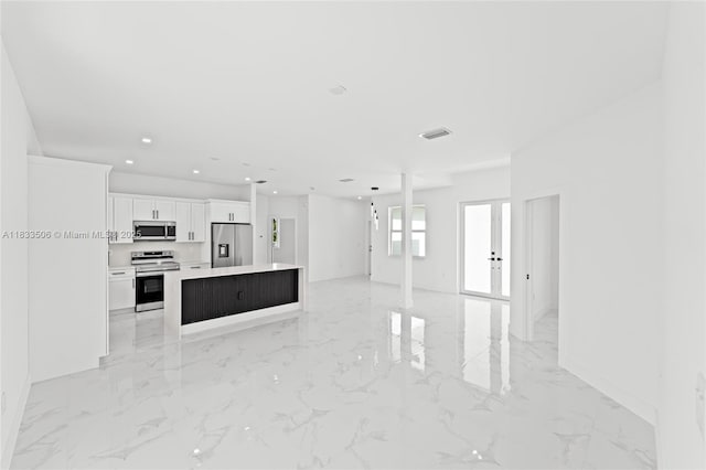 2506 5th St SW, Lehigh Acres, FL 33976 - unfurnished living room featuring recessed lighting, light marble finish floors, and french doors
