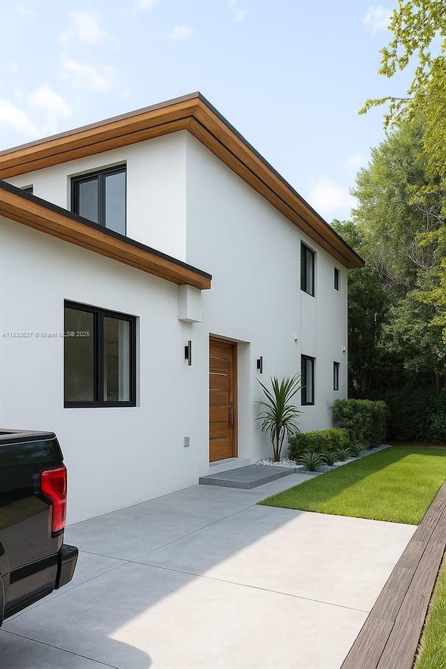 742 NW 70th St, Miami, FL 33150 - rear view of house with stucco siding, a patio area, and a lawn