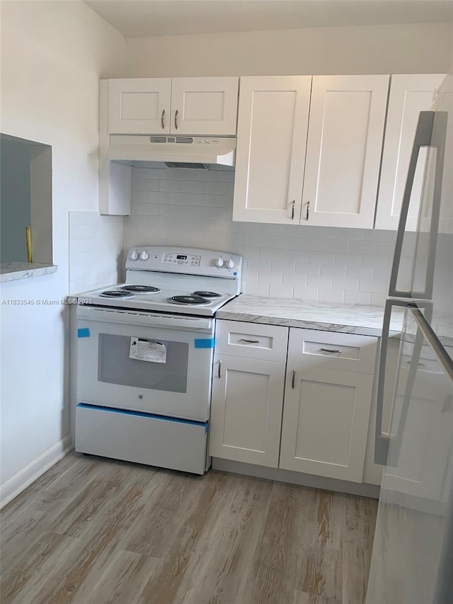 8861 Sunrise Lakes Blvd Unit 307, Sunrise, FL 33322 - kitchen featuring white electric stove, under cabinet range hood, freestanding refrigerator, and white cabinets