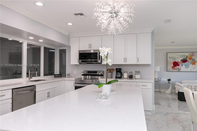 4326 Jackson St, Hollywood, FL 33021 - kitchen with appliances with stainless steel finishes, ornamental molding, light countertops, a chandelier, and light marble finish floors