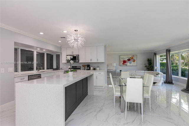 4326 Jackson St, Hollywood, FL 33021 - kitchen with appliances with stainless steel finishes, ornamental molding, a kitchen island, white cabinets, and a chandelier