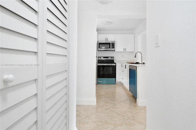 1391 S Ocean Blvd Unit 704, Pompano Beach, FL 33062 - kitchen with stainless steel appliances, white cabinets, light countertops, and light tile patterned floors