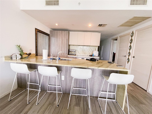 801 S Miami Ave Unit 4204, Miami, FL 33130 - kitchen with wood finished floors, a kitchen breakfast bar, a peninsula, backsplash, and recessed lighting