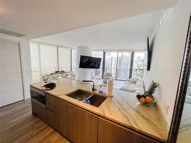 801 S Miami Ave Unit 4204, Miami, FL 33130 - kitchen featuring open floor plan, wood finished floors, brown cabinets, light stone countertops, and floor to ceiling windows