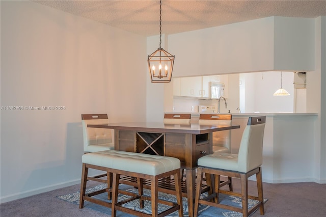 2541 N Nob Hill Rd Unit 309, Sunrise, FL 33322 - kitchen with a chandelier, a textured ceiling, carpet flooring, decorative light fixtures, and white cabinets