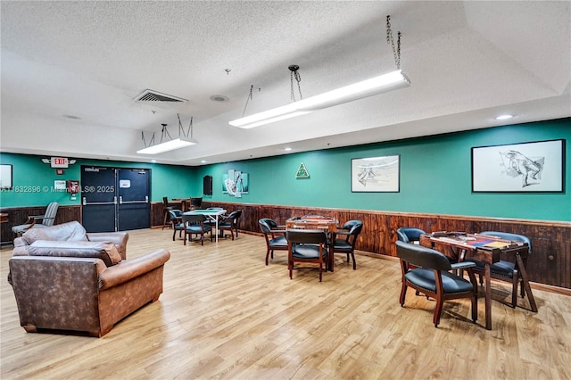 2541 N Nob Hill Rd Unit 309, Sunrise, FL 33322 - dining area featuring a wainscoted wall, wood finished floors, wooden walls, and a textured ceiling