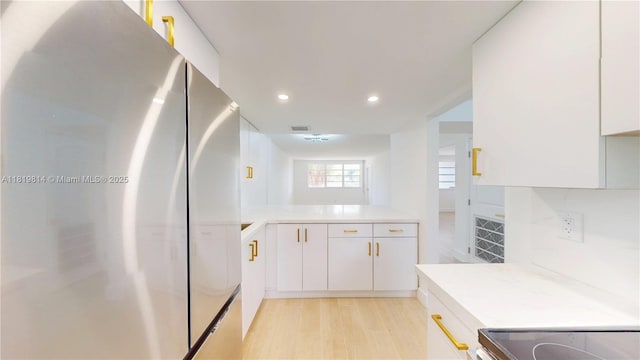 1333 E Hallandale Beach Blvd Unit 326, Hallandale Beach, FL 33009 - kitchen with freestanding refrigerator, light countertops, white cabinetry, recessed lighting, and light wood-style flooring