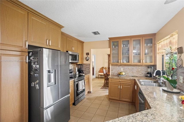 15824 Cotswold Ct, Davie, FL 33331 - kitchen featuring appliances with stainless steel finishes, light tile patterned floors, tasteful backsplash, glass insert cabinets, and light stone counters