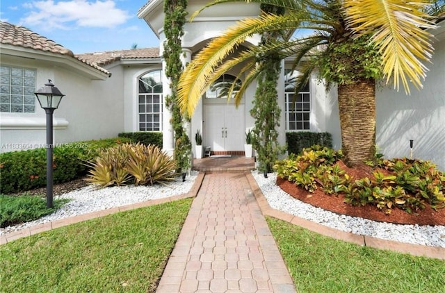 14095 NW 22nd Ct, Pembroke Pines, FL 33028 - view of exterior entry featuring stucco siding and a tile roof