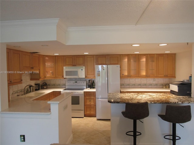1101 River Reach Dr Unit 418, Fort Lauderdale, FL 33315 - kitchen featuring white appliances, ornamental molding, decorative backsplash, a peninsula, and glass insert cabinets
