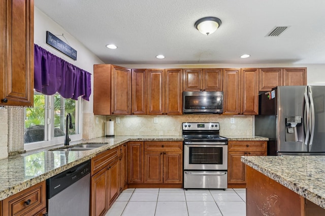 8107 NW 73rd Ter, Tamarac, FL 33321 - kitchen featuring stainless steel appliances, light stone countertops, brown cabinetry, light tile patterned floors, and recessed lighting