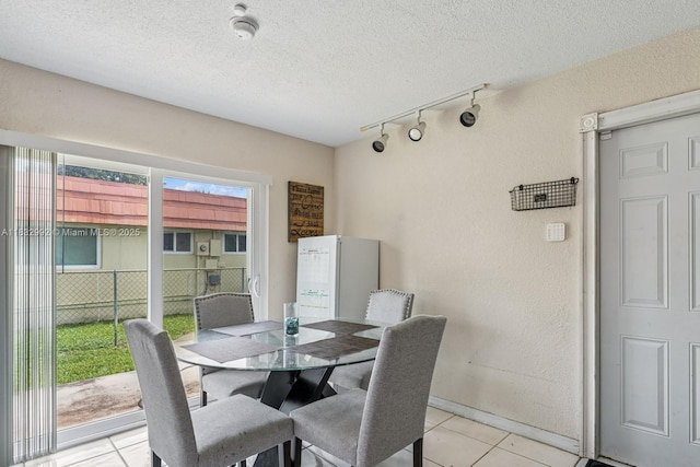 8107 NW 73rd Ter, Tamarac, FL 33321 - dining room featuring track lighting, light tile patterned floors, a textured ceiling, and a textured wall
