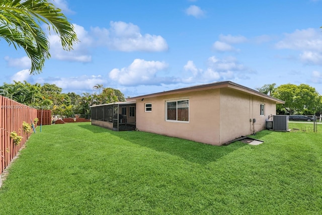 8107 NW 73rd Ter, Tamarac, FL 33321 - back of house with a sunroom, stucco siding, and a fenced backyard