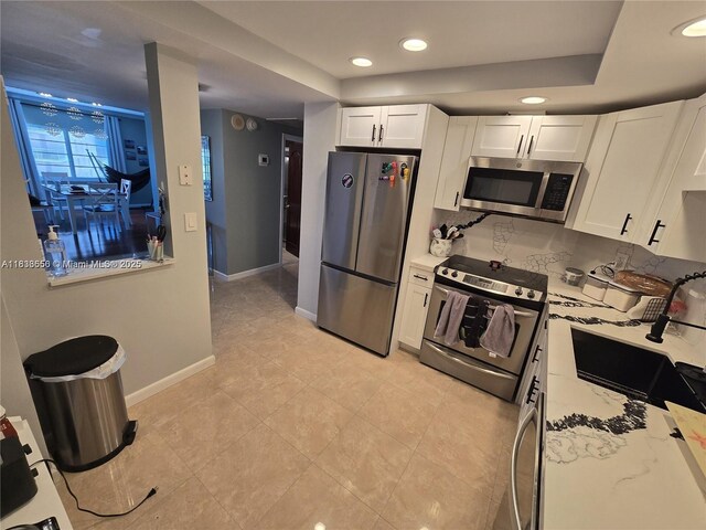 500 Bayview Dr Unit 732, Sunny Isles Beach, FL 33160 - kitchen with appliances with stainless steel finishes, white cabinetry, tasteful backsplash, recessed lighting, and light tile patterned flooring