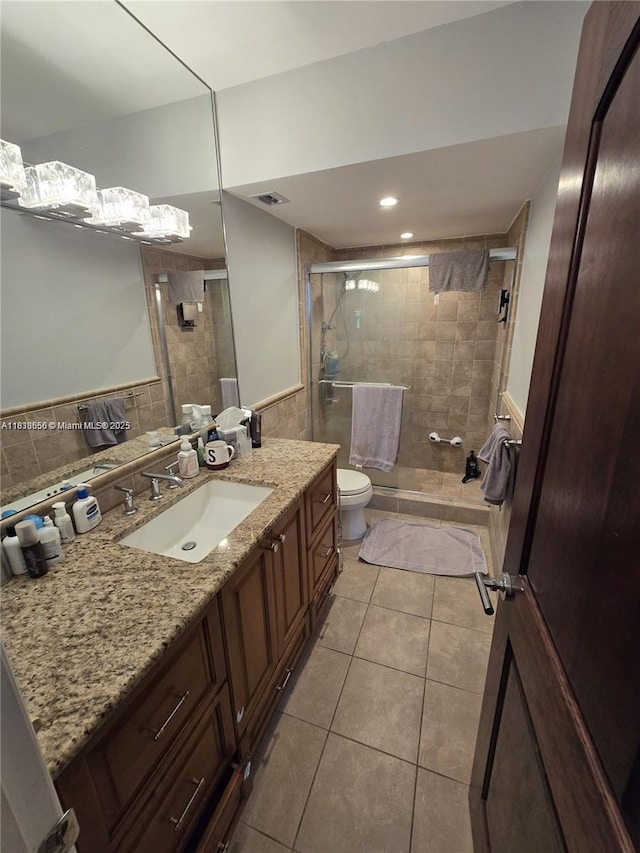 500 Bayview Dr Unit 732, Sunny Isles Beach, FL 33160 - bathroom featuring tile walls, tile patterned floors, a shower stall, vanity, and wainscoting
