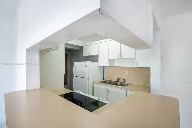 719 Euclid Ave Unit 7, Miami Beach, FL 33139 - kitchen with freestanding refrigerator, stovetop, white cabinets, and light countertops