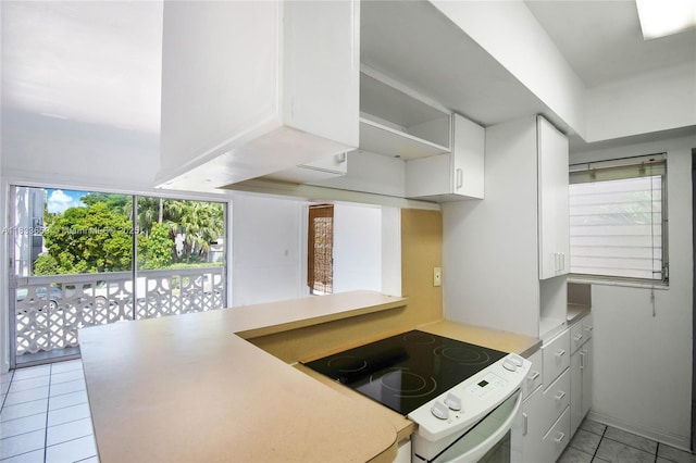 719 Euclid Ave Unit 7, Miami Beach, FL 33139 - kitchen featuring electric stove, light tile patterned floors, light countertops, white cabinets, and open shelves