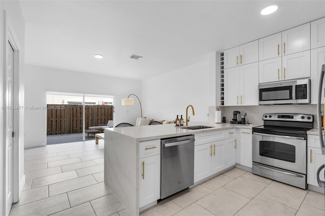 8242 NW 107th Ct Unit 7-12, Doral, FL 33178 - kitchen with appliances with stainless steel finishes, white cabinetry, a peninsula, and recessed lighting