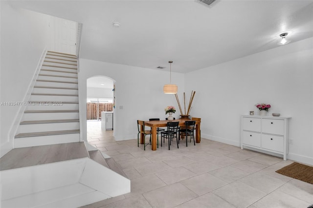 8242 NW 107th Ct Unit 7-12, Doral, FL 33178 - dining room featuring arched walkways, stairs, and light tile patterned floors