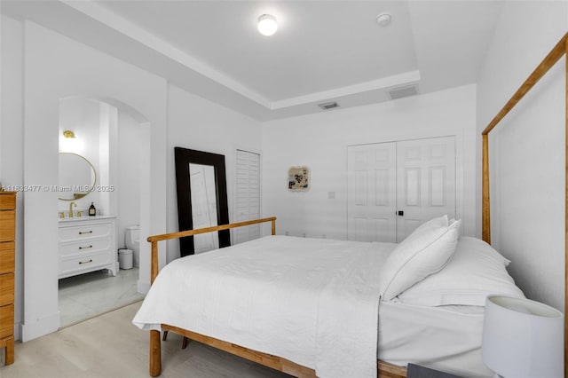 8242 NW 107th Ct Unit 7-12, Doral, FL 33178 - bedroom featuring arched walkways, a closet, and light wood-style floors