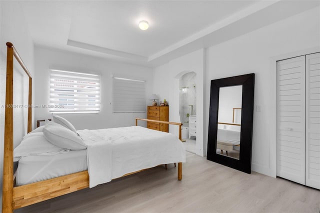 8242 NW 107th Ct Unit 7-12, Doral, FL 33178 - bedroom featuring arched walkways, a raised ceiling, and wood finished floors