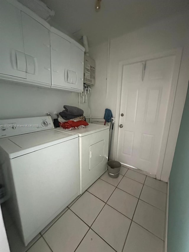 6443 Perry St, Hollywood, FL 33024 - laundry area with washer and dryer, cabinet space, light tile patterned floors, and water heater