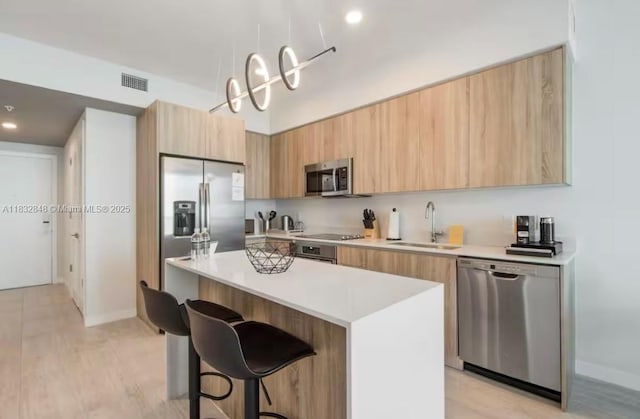 3900 Biscayne Blvd Unit S-1020, Miami, FL 33137 - kitchen featuring appliances with stainless steel finishes, modern cabinets, a breakfast bar area, a kitchen island, and light countertops