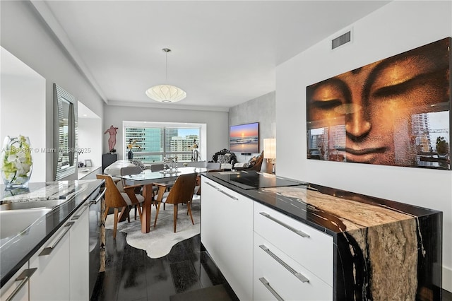 1435 Brickell Ave Unit 3512, Miami, FL 33131 - kitchen featuring white cabinets, dark countertops, decorative light fixtures, modern cabinets, and black electric stovetop