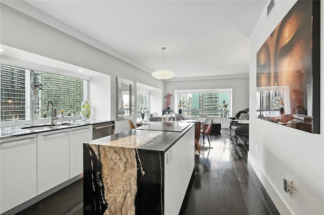 1435 Brickell Ave Unit 3512, Miami, FL 33131 - kitchen featuring white cabinets, modern cabinets, dark wood-type flooring, a center island, and hanging light fixtures
