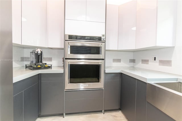 8694 Via Reale Unit 61L, Boca Raton, FL 33496 - kitchen with stainless steel double oven, modern cabinets, and gray cabinets