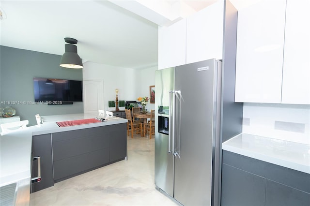 8694 Via Reale Unit 61L, Boca Raton, FL 33496 - kitchen with stainless steel fridge, modern cabinets, light countertops, and hanging light fixtures