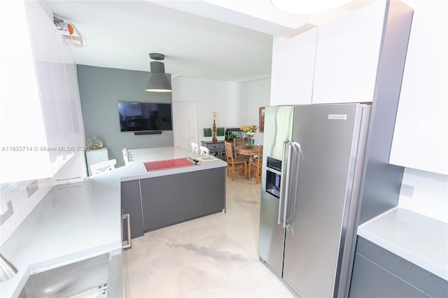 8694 Via Reale Unit 61L, Boca Raton, FL 33496 - kitchen with stainless steel fridge, modern cabinets, light countertops, white cabinets, and cooktop