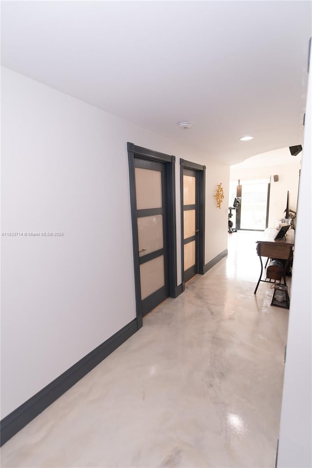 8694 Via Reale Unit 61L, Boca Raton, FL 33496 - hall with finished concrete flooring and baseboards