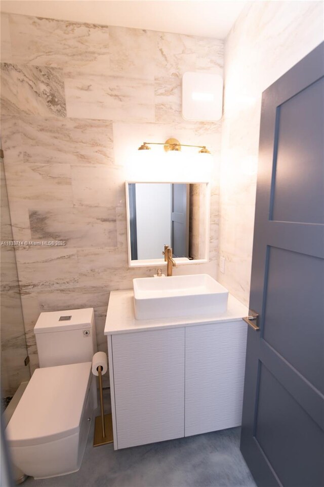 8694 Via Reale Unit 61L, Boca Raton, FL 33496 - bathroom with vanity, tile walls, and concrete flooring