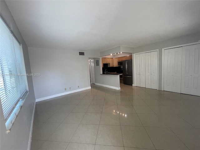 4051 NE 13th Ave Unit 55-3, Oakland Park, FL 33334 - unfurnished living room with light tile patterned flooring and baseboards
