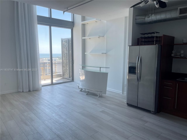 690 SW 1st Ct Unit 19, Miami, FL 33130 - kitchen with stainless steel fridge with ice dispenser, light wood finished floors, ceiling fan, and a wall of windows