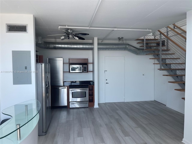 690 SW 1st Ct Unit 19, Miami, FL 33130 - kitchen with stainless steel appliances, electric panel, wood finished floors, and ceiling fan