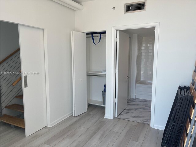 690 SW 1st Ct Unit 19, Miami, FL 33130 - unfurnished bedroom with light wood finished floors and connected bathroom