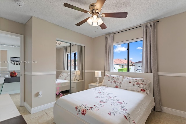5400 NW 184th St, Miami Gardens, FL 33055 - bedroom featuring a closet, a textured ceiling, a ceiling fan, and light tile patterned floors