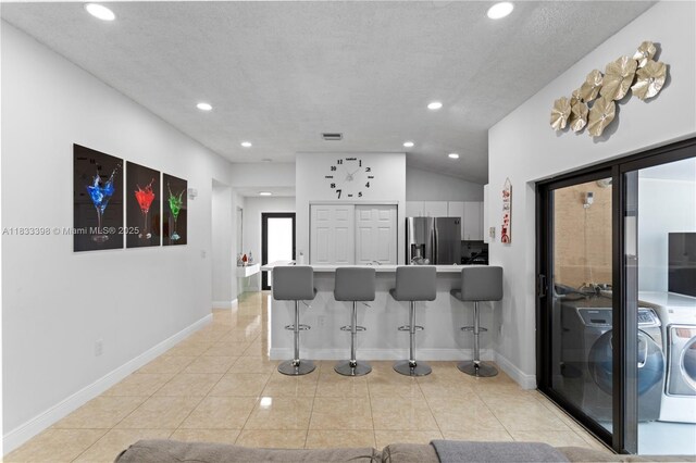 5400 NW 184th St, Miami Gardens, FL 33055 - kitchen featuring stainless steel fridge with ice dispenser, washing machine and clothes dryer, a kitchen breakfast bar, recessed lighting, and light tile patterned floors