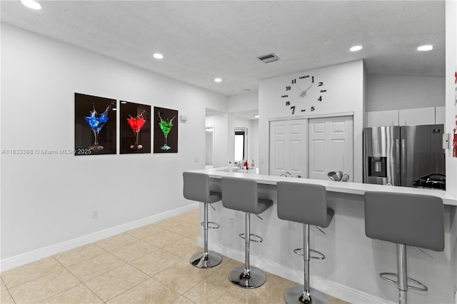 5400 NW 184th St, Miami Gardens, FL 33055 - kitchen featuring stainless steel refrigerator with ice dispenser, a breakfast bar, recessed lighting, light countertops, and a peninsula