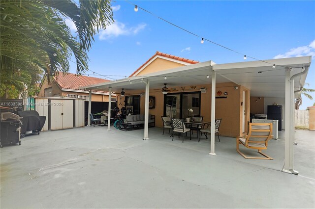 5400 NW 184th St, Miami Gardens, FL 33055 - rear view of house featuring an outdoor living space, stucco siding, ceiling fan, a patio, and a storage shed