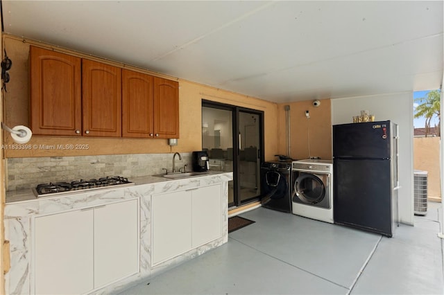 5400 NW 184th St, Miami Gardens, FL 33055 - kitchen with freestanding refrigerator, stainless steel gas stovetop, independent washer and dryer, brown cabinets, and light countertops