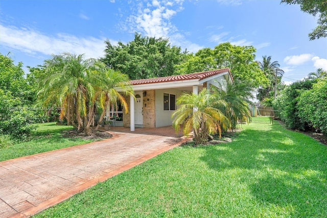 220 NW 35th Ct, Oakland Park, FL 33309 - view of front of property featuring a tiled roof, a front lawn, and stucco siding