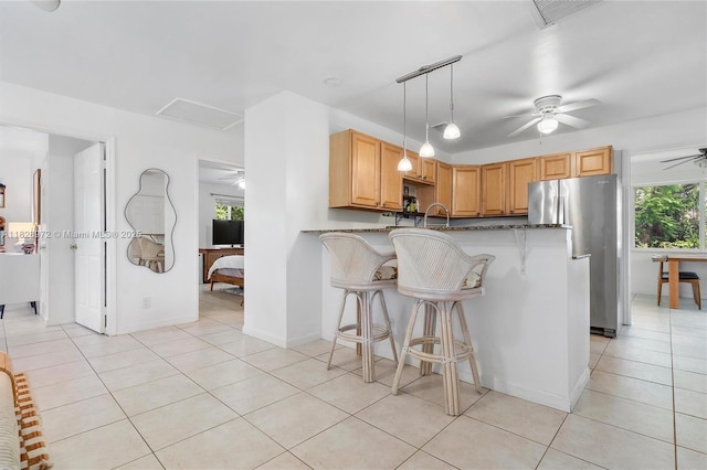 220 NW 35th Ct, Oakland Park, FL 33309 - kitchen with freestanding refrigerator, a ceiling fan, plenty of natural light, and a breakfast bar area