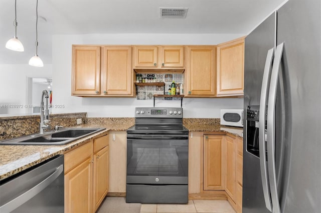 220 NW 35th Ct, Oakland Park, FL 33309 - kitchen with stainless steel appliances, light brown cabinetry, and light stone countertops