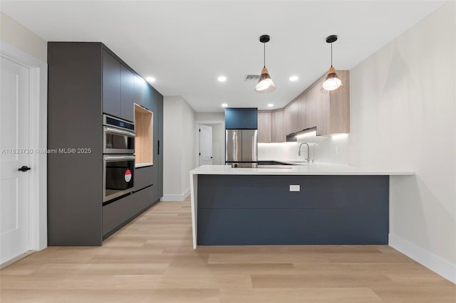1340 SW 27th Pl, Boynton Beach, FL 33426 - kitchen featuring stainless steel appliances, a peninsula, modern cabinets, light countertops, and recessed lighting