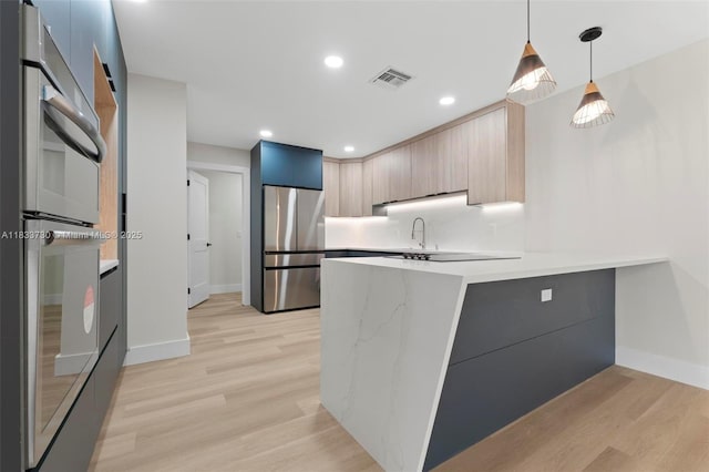 1340 SW 27th Pl, Boynton Beach, FL 33426 - kitchen featuring appliances with stainless steel finishes, modern cabinets, a peninsula, light wood finished floors, and recessed lighting