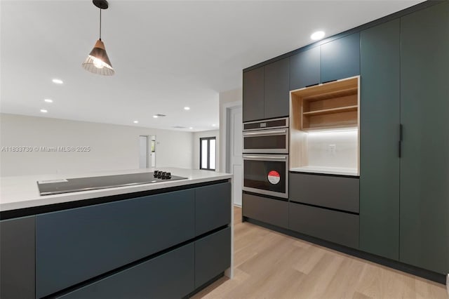 1340 SW 27th Pl, Boynton Beach, FL 33426 - kitchen with black electric cooktop, light wood-style floors, stainless steel double oven, decorative light fixtures, and modern cabinets