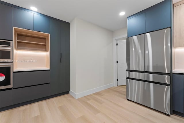 1340 SW 27th Pl, Boynton Beach, FL 33426 - kitchen featuring stainless steel appliances, light wood-style floors, blue cabinets, recessed lighting, and light countertops